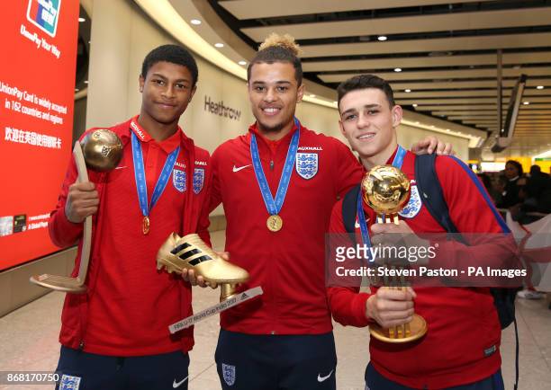 England's Rhian Brewster, Joel Latibeaudiere and Phil Foden pose for a photo as the Under-17 World Cup winning side arrive back to the UK, at...