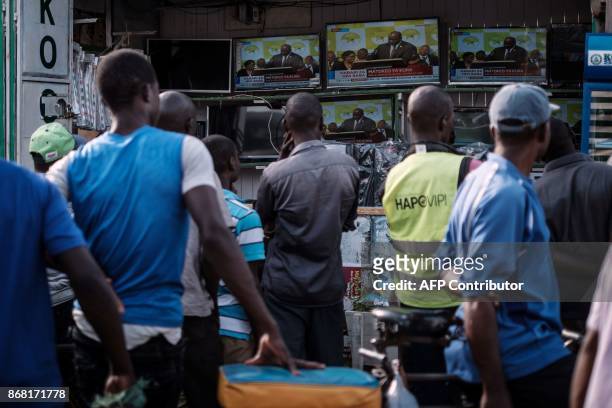 People watch live broadcast of the announcement of the re-election's result by Kenya's Independent Electoral and Boundaries Commission chairman,...