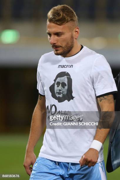 Lazio's midfielder Ciro Immobile wears a t-shirt against antisemitism showing an image of holocaust victim Anne Frank, during the warm up prior the...