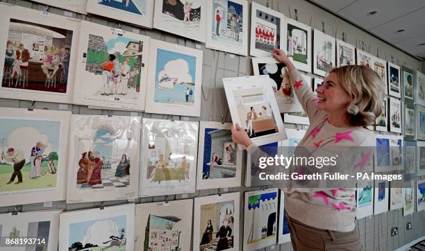 Auctioneer Catherine Southon holds examples from the Smilby cartoon collection, including works that appeared in Playboy, as she sets up her sale...