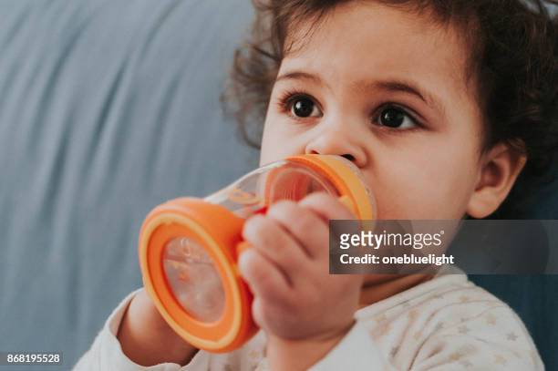 kleinkind mit ihrem baby-flasche - onebluelight stock-fotos und bilder