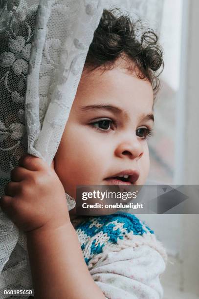 toddler lokking out window - onebluelight stock pictures, royalty-free photos & images