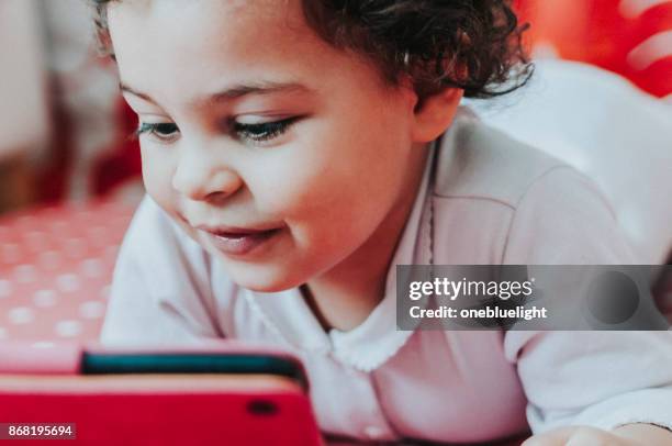 toddler playing with digital tablet. - onebluelight stock pictures, royalty-free photos & images
