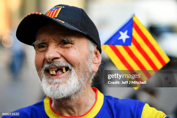 An independence supporter waves a flag outside the Palau Catalan Regional Government Building as Catalonia returns to work following last week's...