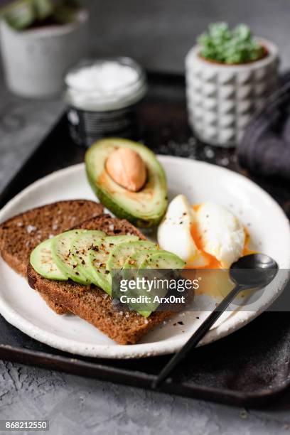 avocado rye toast with poached egg - escalfado fotografías e imágenes de stock