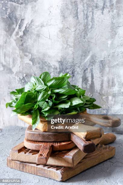 fresh basil on wooden cutting board - mediterran menü stock-fotos und bilder