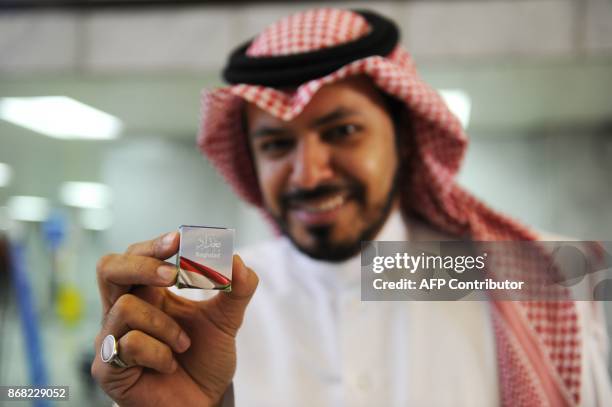 Customer holds a small gift box from the Saudi Airlines check-in desk at the airport in the Red Sea city of Jeddah, as the state-owned airline...