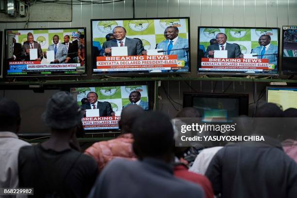 People watch live broadcast as Uhuru Kenyatta is declared the winner following presidential re-election results by Kenya's Independent Electoral and...