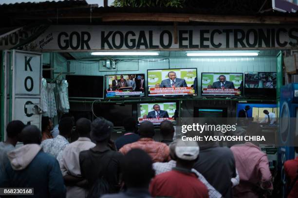 People watch live broadcast as Uhuru Kenyatta is declared the winner following presidential re-election results by Kenya's Independent Electoral and...