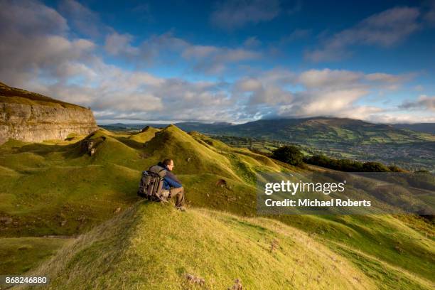 hiker in the llangattock escarpment quarries looking towards crickhowell, in the brecon beacons national park, wales - brecon beacons stock pictures, royalty-free photos & images
