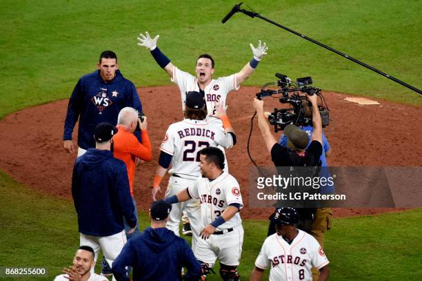 Alex Bregman of the Houston Astros is mobbed by teammates after hitting the game-winning RBI single in the 10th inning during Game 5 of the 2017...