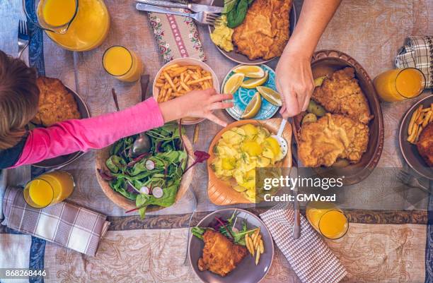 eating wiener schnitzel with potatoes and green salad - austrian culture stock pictures, royalty-free photos & images