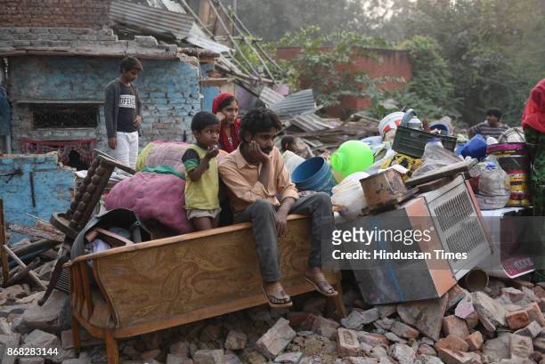 Man sits near his demolished shanty as a demolition drive has been undertaken by DDA at Katputli Colony, Shadipur on October 30, 2017 in New Delhi,...