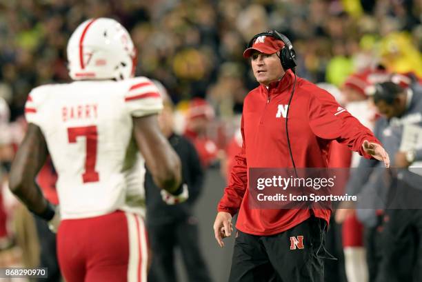 Nebraska Cornhuskers defensive line coach John Parrella high fives players as they exit the field during the Big Ten conference game between the...