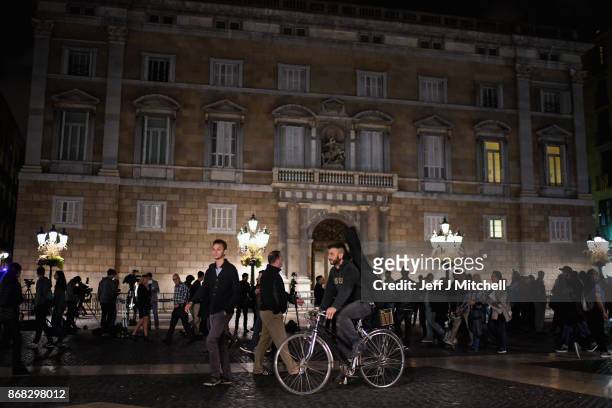 Members of the public walk past the Palau Catalan Regional Government Building as Catalonia as television crews broadcast following last week's...