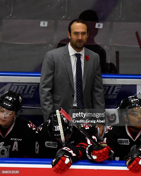 Head Coach Billy Burke of the Niagara IceDogs watches the play develop against the Mississauga Steelheads during game action on October 29, 2017 at...