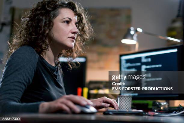 beautyful, concentrated,  female computer hacker stealing information with  computer equipment - dark web stock pictures, royalty-free photos & images