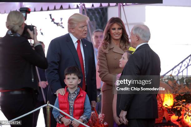 President Donald Trump and first lady Melania Trump greet Attorney General Jeff Sessions and the children he was accompanying while hosting Halloween...