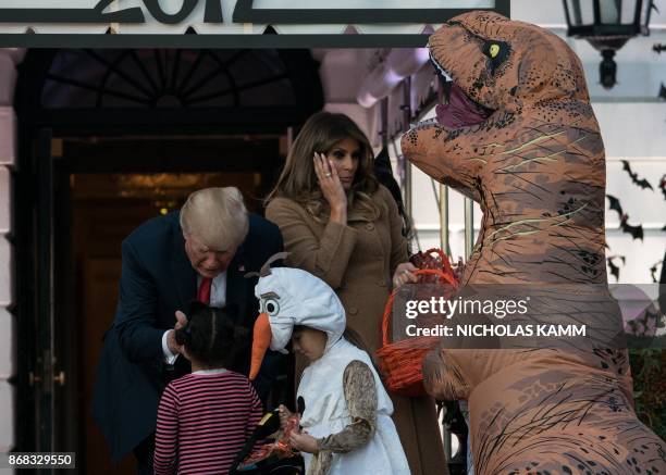 President Donald Trump and First Lady Melania Trump hand out candy to children during a Halloween event at the White House in Washington, DC, on...