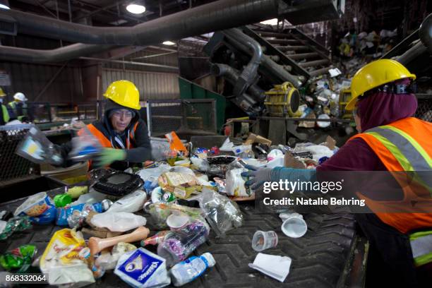 Workers sort paper and plastic waste at Far West Recycling October 30, 2017 in Hillsboro, Oregon. China is sharply restricting imports on recycled...