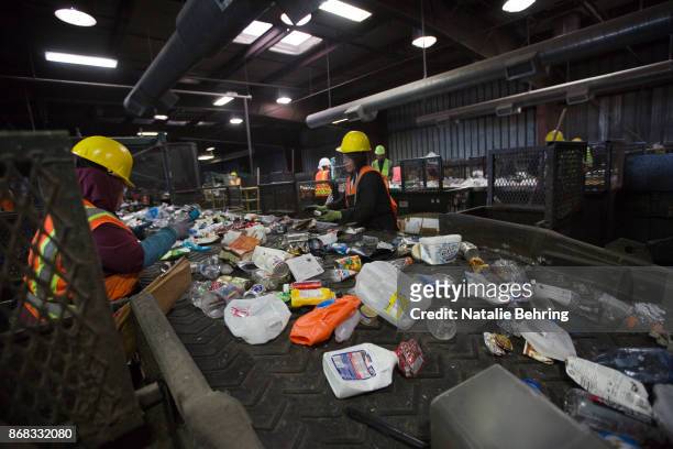 Workers sort paper and plastic waste at Far West Recycling October 30, 2017 in Hillsboro, Oregon. China is sharply restricting imports on recycled...