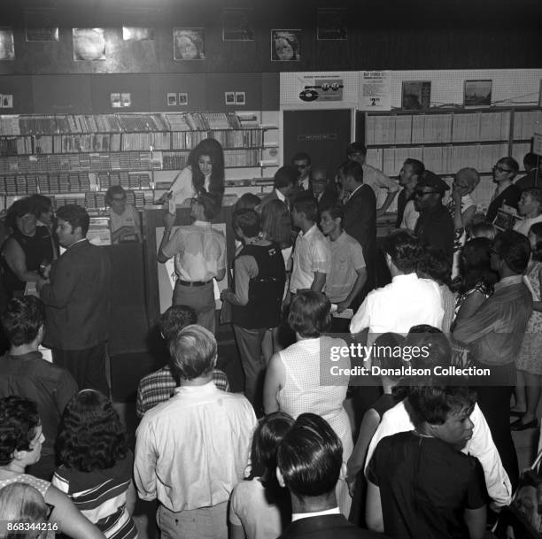 Singer Bobbie Gentry signs autographs at Korvette's record store on July 24, 1968 in New York.