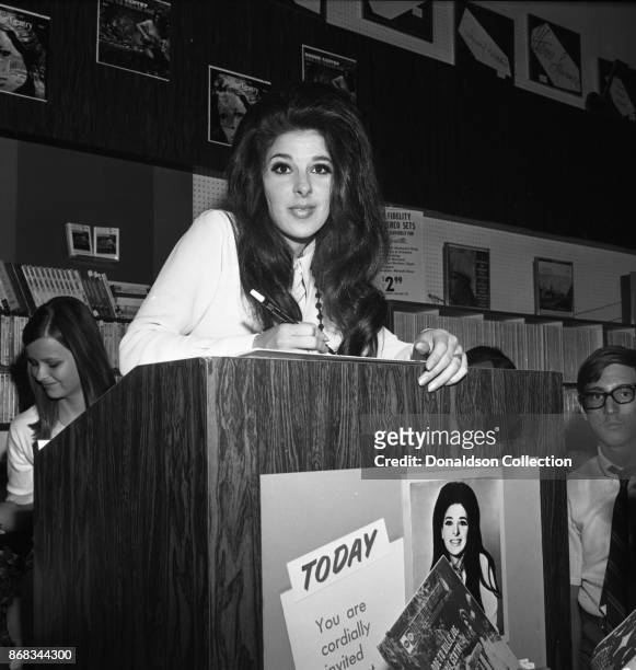 Singer Bobbie Gentry signs autographs at Korvette's record store on July 24, 1968 in New York.