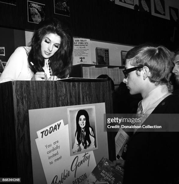 Singer Bobbie Gentry signs autographs at Korvette's record store on July 24, 1968 in New York.