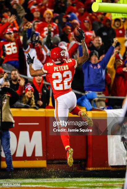 Cornerback Marcus Peters of the Kansas City Chiefs goes up to dunk the football over the goal post after returning a fumble for a touchdown against...