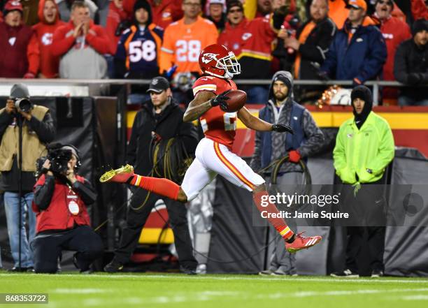 Cornerback Marcus Peters of the Kansas City Chiefs high steps after returning a fumble on his way to a touchdown against the Denver Broncos during...