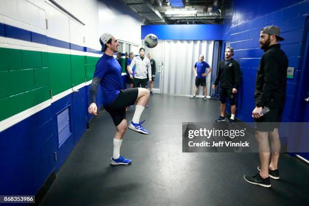 Jayson Megna of the Vancouver Canucks knees a soccer ball as he warms up with teammates before their NHL game against the Dallas Stars at Rogers...