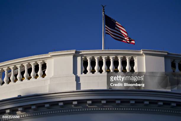 The American flag flies over the White House in Washington, D.C., U.S., on Monday, Oct. 30, 2017. President Donald Trump greeted costumed children...
