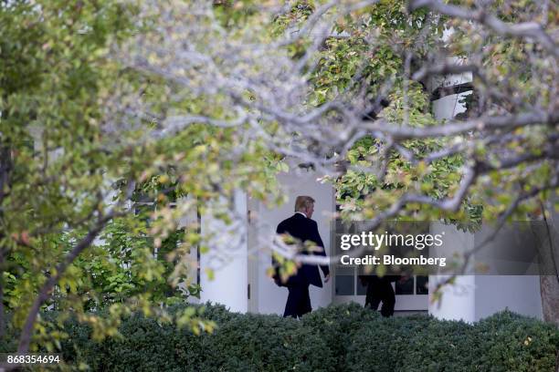 President Donald Trump walks through the Colonnade of the White House in Washington, D.C., U.S., on Monday, Oct. 30, 2017. Trump greeted costumed...