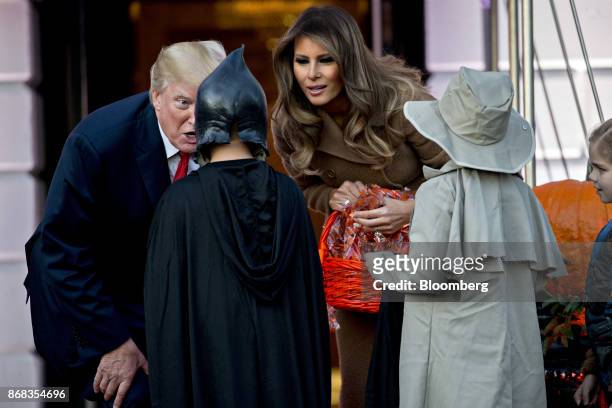 President Donald Trump, left, and U.S. First Lady Melania Trump greet children dressed up in costumes during a Halloween event on the South Lawn of...