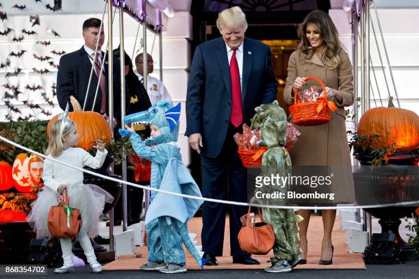President Donald Trump, center, and U.S. First Lady Melania Trump, right, greet children dressed up in costumes during a Halloween event on the South...