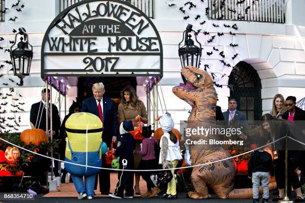 President Donald Trump, left, and U.S. First Lady Melania Trump, center, greet children dressed up in costumes during a Halloween event on the South...
