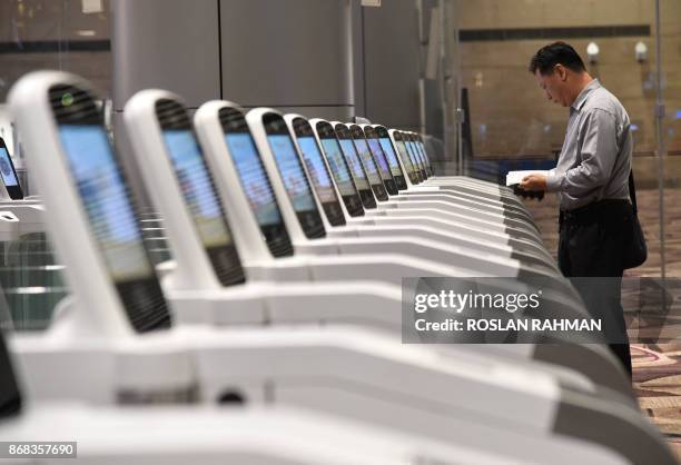 Passenger goes through an automated immigration gate at the newly-opened Singapore Changi Airport's Terminal 4 in Singapore on October 31, 2017. -...