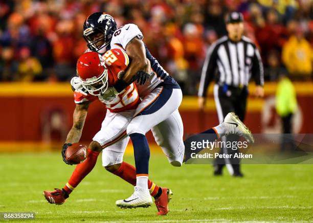 Cornerback Marcus Peters of the Kansas City Chiefs is tackled by tight end Virgil Green of the Denver Broncos after making an interception during the...