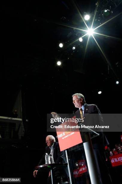 New York City Mayor Bill de Blasio speaks to supporters next to Sen. Bernie Sanders as they take part in a campaign rally on October 30, 2017 in New...