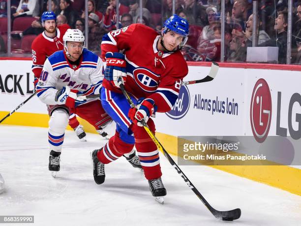 Brandon Davidson of the Montreal Canadiens skates the puck against Michael Grabner of the New York Rangers during the NHL game at the Bell Centre on...