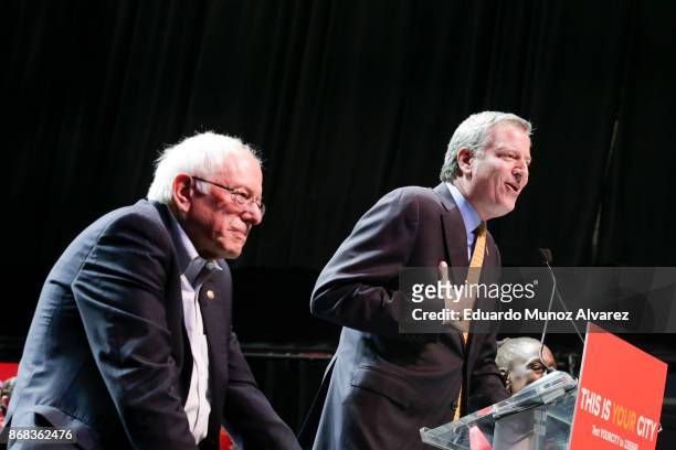 New York City Mayor Bill de Blasio speaks to supporters next to Sen. Bernie Sanders as they take part in a campaign rally on October 30, 2017 in New...