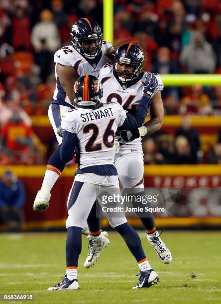 Nose tackle Domata Peko of the Denver Broncos celebrates with Zach Kerr and free safety Darian Stewart after recovering a fumble during the game...