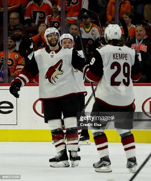 Alex Goligoski of the Arizona Coyotes celebrates his game winning goal with teammate Mario Kempe in the overtime period against the Philadelphia...