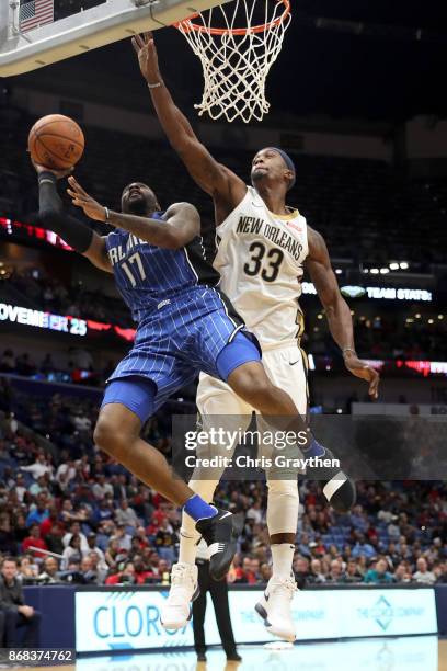 Jonathon Simmons of the Orlando Magic makes a shot over E'Twaun Moore of the New Orleans Pelicans at the Smoothie King Center on October 30, 2017 in...