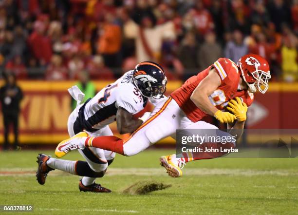 Kansas City Chiefs tight end Travis Kelce is brought down by Denver Broncos defensive back Will Parks after a catch during the third quarter on...