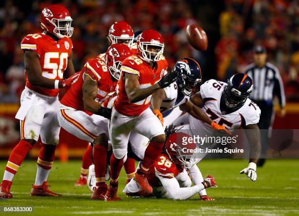 Cornerback Marcus Peters of the Kansas City Chiefs forces a fumble by running back Jamaal Charles of the Denver Broncos during the game at Arrowhead...