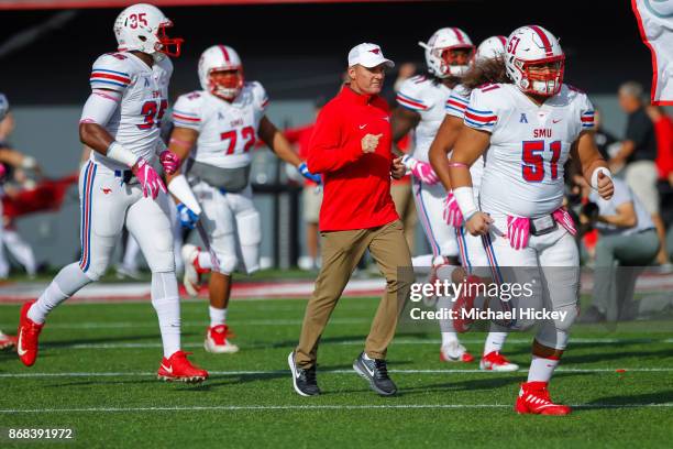 Head coach Chad Morris of the Southern Methodist Mustangs runs out with the team before the game against the Cincinnati Bearcats at Nippert Stadium...