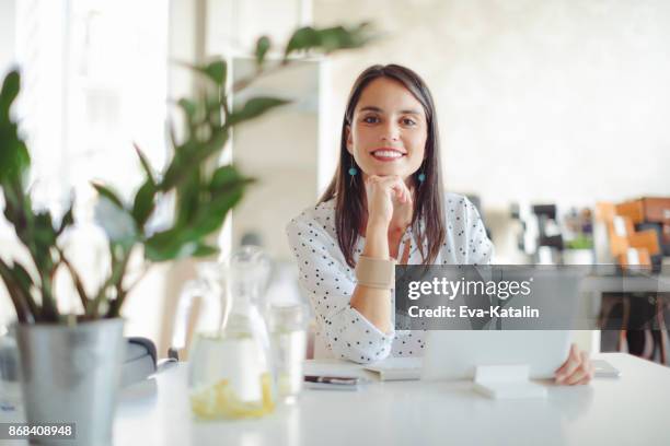 young woman working in her offfice - eva long stock pictures, royalty-free photos & images