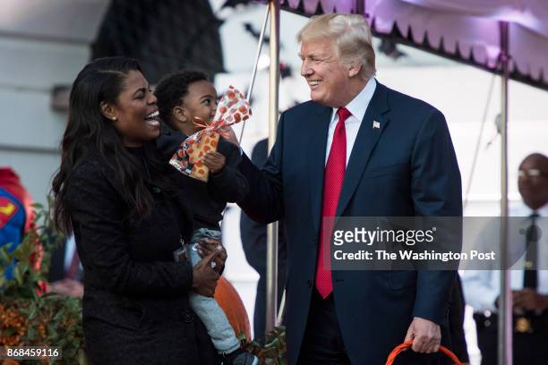 White House Director of communications for the Office of Public Liaison Omarosa Manigault talks with President Donald Trump as he hands out treats as...