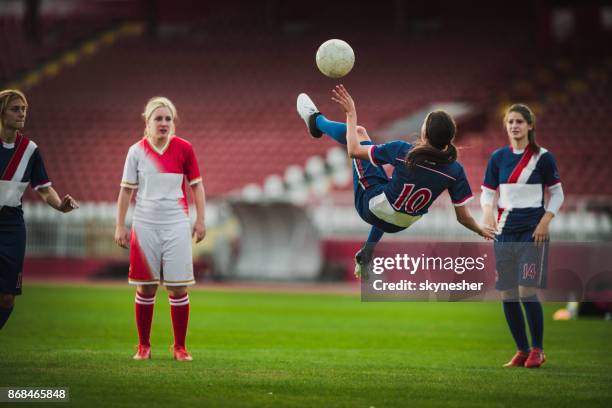 skillful female soccer striker doing bicycle kick during the game. - bicycle kick stock pictures, royalty-free photos & images